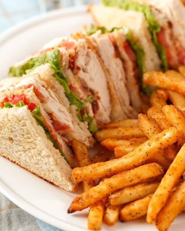 Freshly made club sandwich with crisp vegetables and layers at Cocoi Cafe